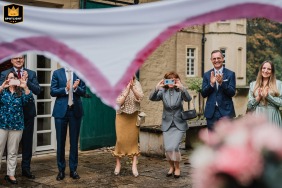   Guests at Schloss Heeren in Kamen, Germany, delight in watching the couple cut out a heart-shaped design from a bed sheet, enthusiastically celebrating their union with laughter and cheers.